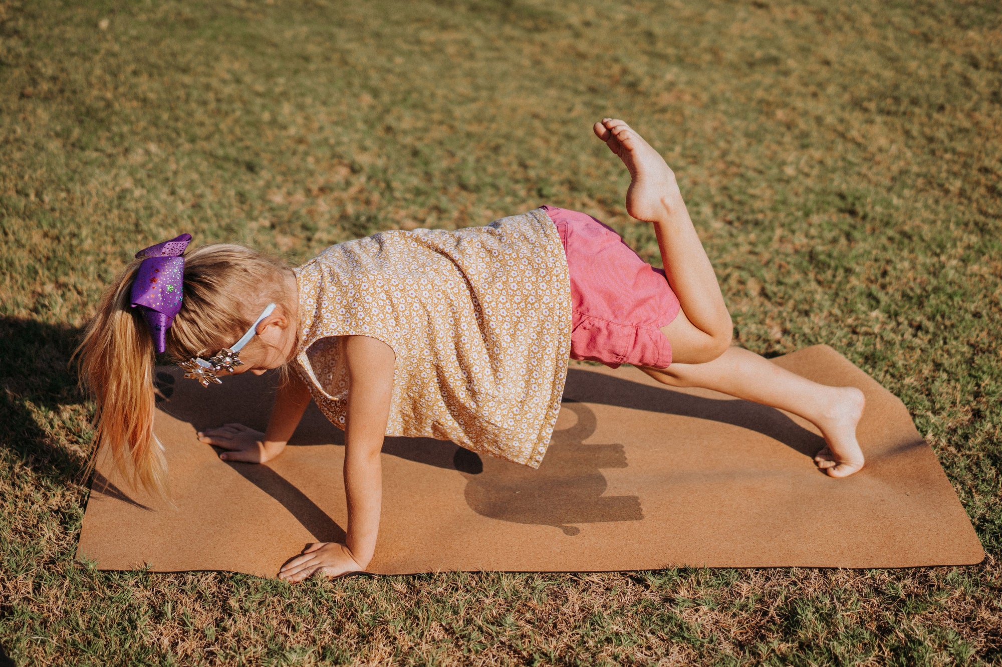 Little blond girl practicing yoga on Lauryan child yoga mat