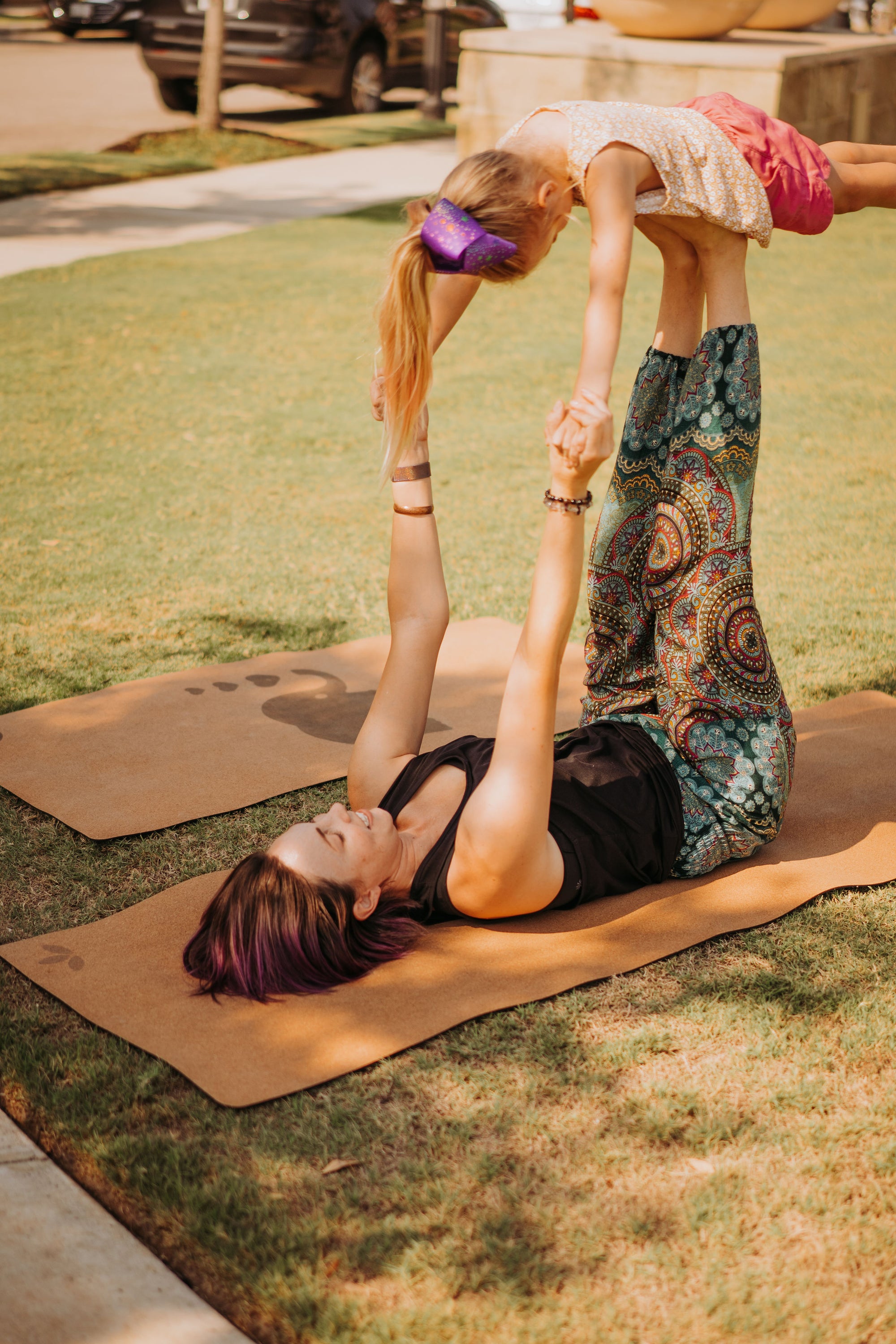 Yogi mom practicing acro yoga with her daughter on Lauryan cork yoga mat