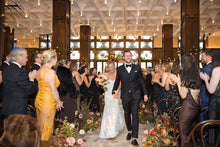 Load image into Gallery viewer, Bride and groom smiling as they exit their wedding ceremony aisle to cheering guests