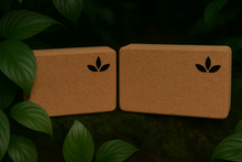 Load image into Gallery viewer, Two cork yoga blocks with leaf logo on a dark green background