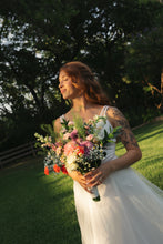 Load image into Gallery viewer, Bride Tribe bridesmaid set — Savanna in golden hour light holding a floral bouquet